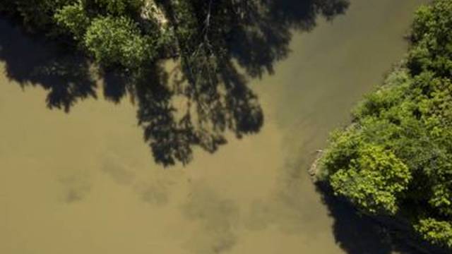 Downstream from Inland Environmental & Remediation, Inc., contaminated water empties from Skull creek into the Colorado River south of Columbus, Texas, on April 14, 2019.