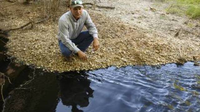Colorado County Groundwater Conservation District board member Andrew Labay, who is also a fisheries biologist, near polluted water flowing in Skull Creek south of Columbus, Texas, on April 14, 2019.